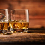 Two glasses of bourbon whiskey with ice cubes - Rip Van Winkle vs Pappy Van Winkle